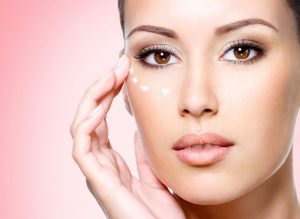 moça passando creme no rosto